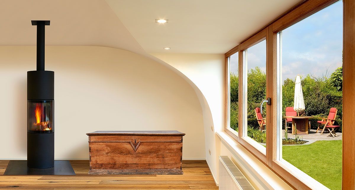 Maison avec un poêle à bois et des fenêtres en bois