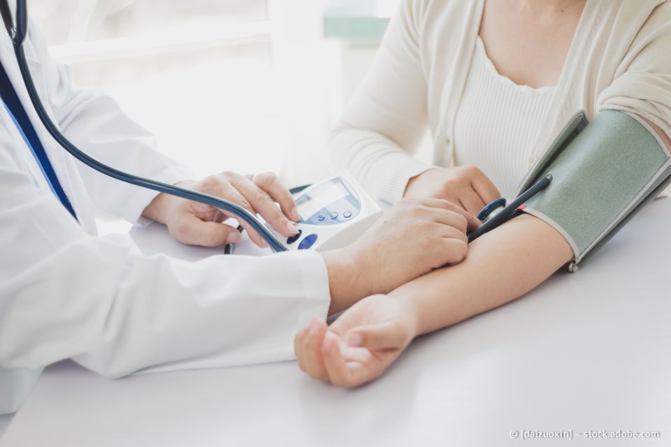 Ein Arzt misst in einer medizinischen Einrichtung den Blutdruck eines Patienten mit einem Stethoskop.