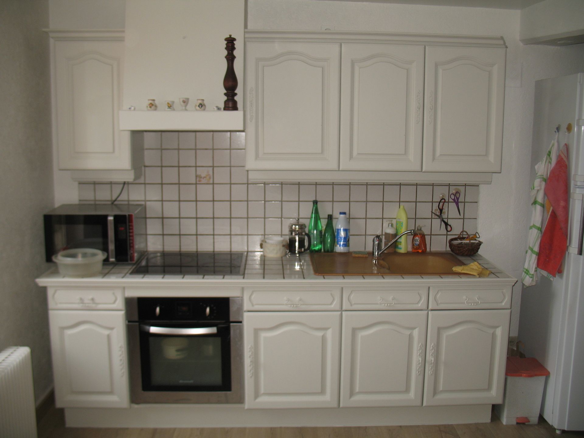 Armoires et appareils de cuisine blancs avec dosseret en carrelage.