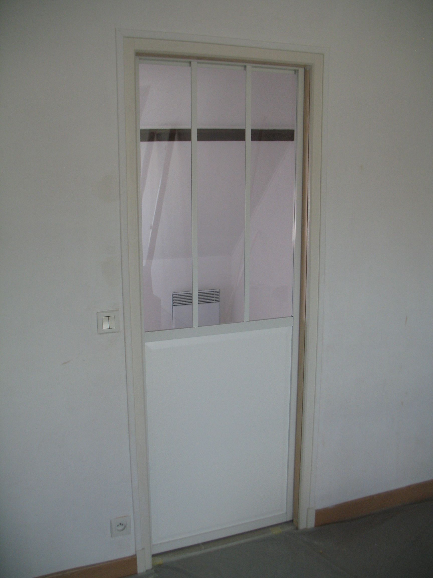 Porte blanche avec panneaux supérieurs en verre et panneau inférieur plein, insérée dans un cadre blanc.