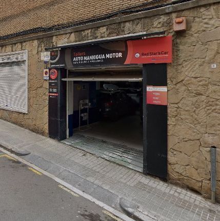 Un garaje con un cartel rojo al costado.