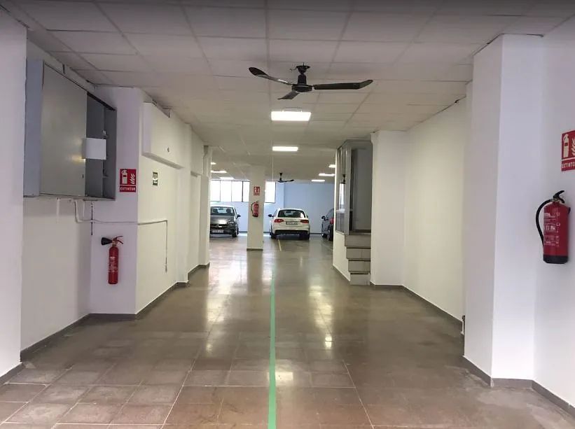 Un pasillo vacío con un extintor en la pared.