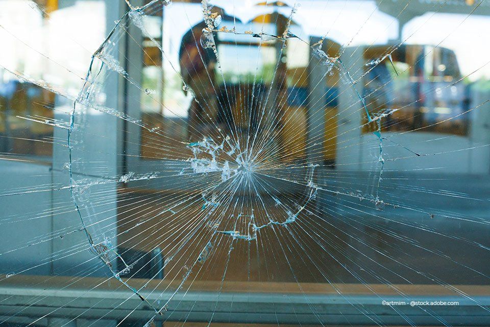 Mitarbeiter der Aacotec Glasereigesellschaft mbH betrachtet zerbrochene Schaufensterscheibe