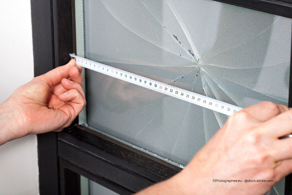 Mitarbeiter Aacotec Glasereigesellschaft mbH misst eine kaputtes Fenster aus