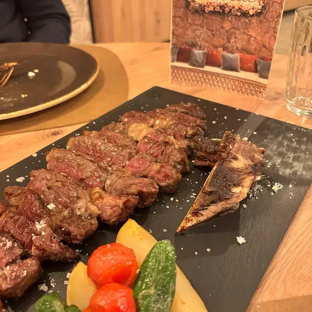 Un plato de carne y verduras en una mesa