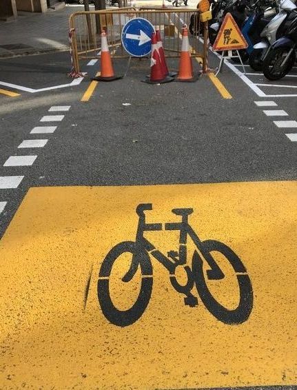 Una bicicleta está pintada al costado de la carretera.