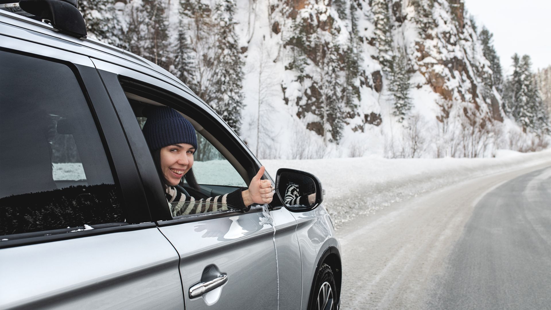 Une personne souriante dans une voiture.