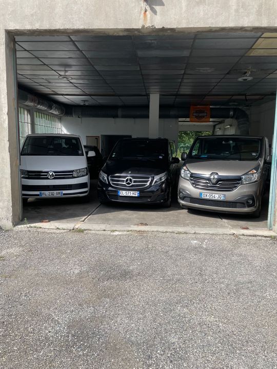 Un hangar avec trois véhicules.