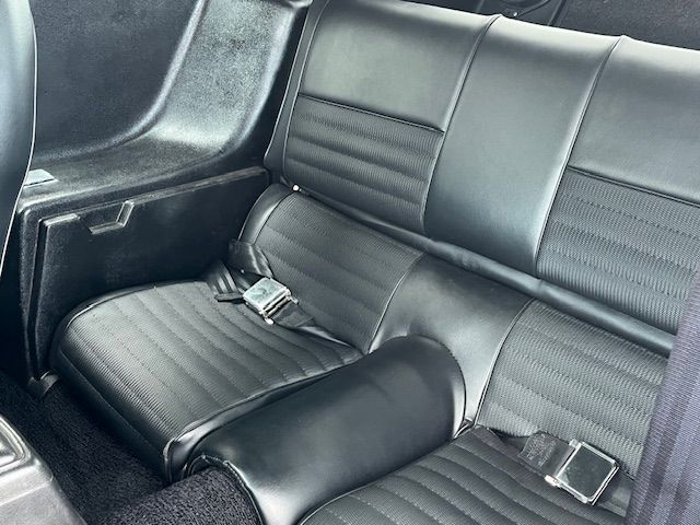 Sièges arrière de voiture en cuir noir avec ceintures de sécurité.