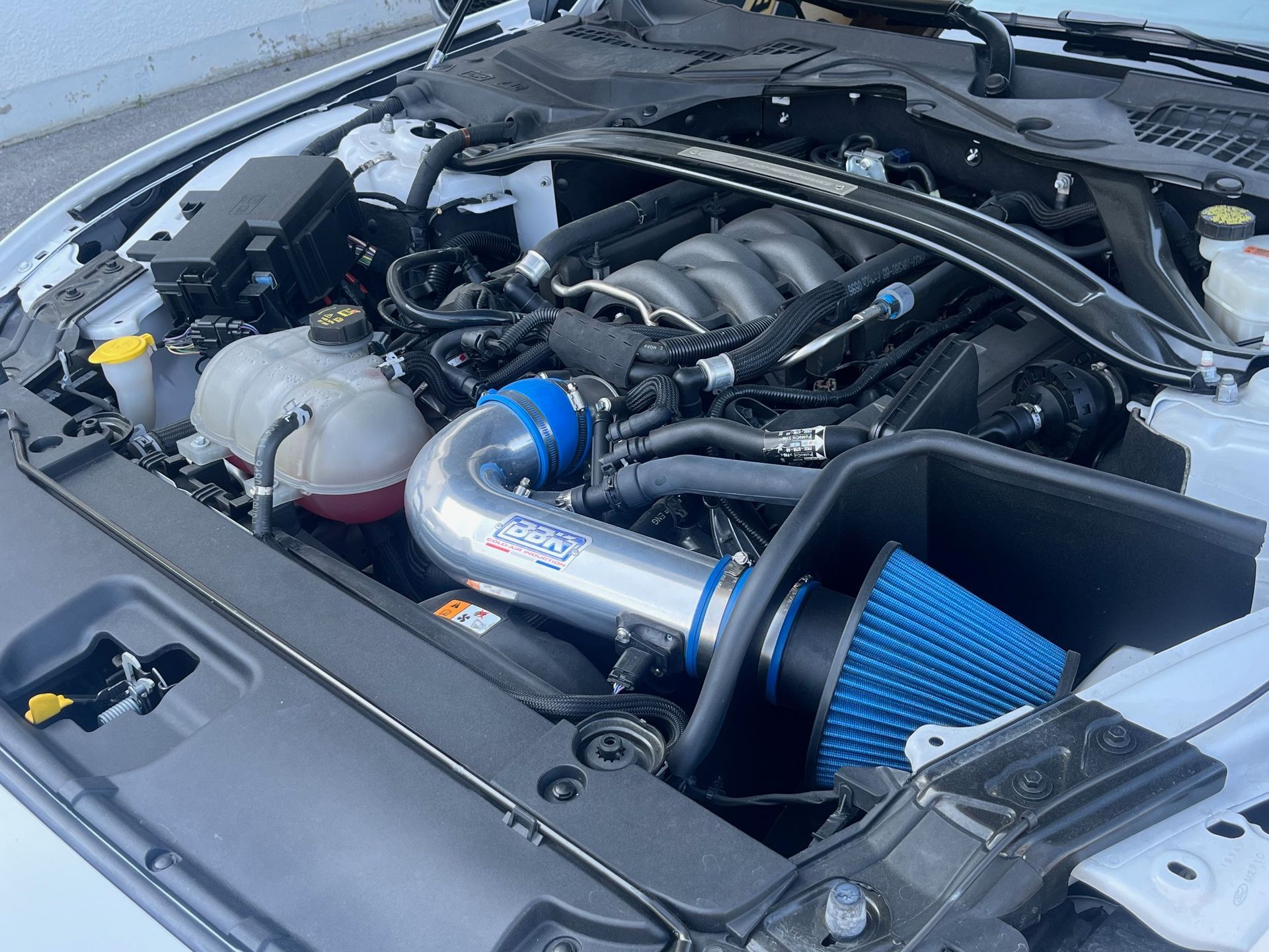 Compartiment moteur avec admission d'air bleue adaptable et tuyauterie polie installées.