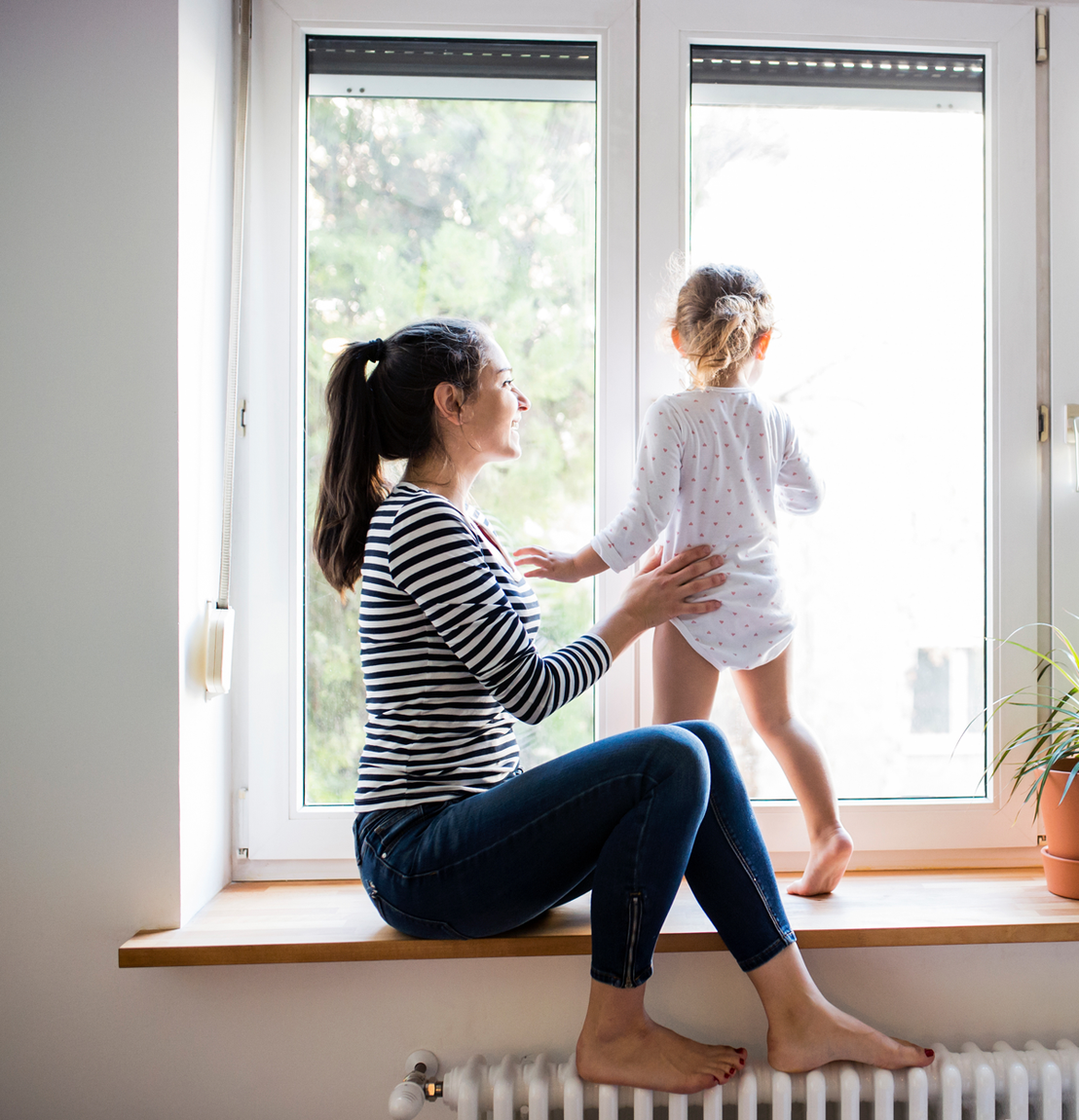 Femme assise sur un rebord de fenêtre en tenant un enfant