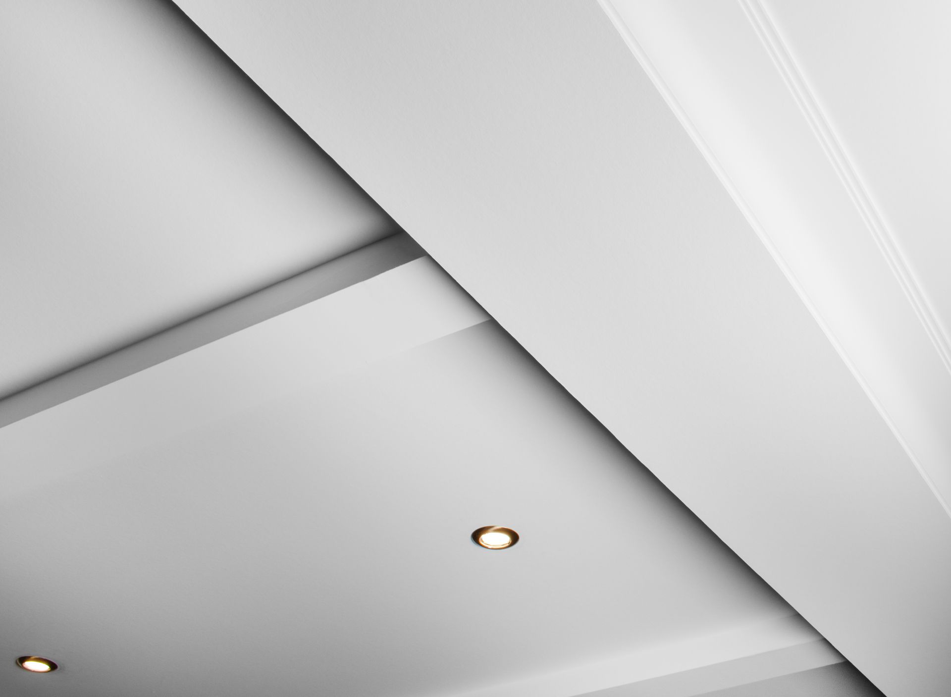 Plafond blanc avec éclairage encastré et moulures décoratives