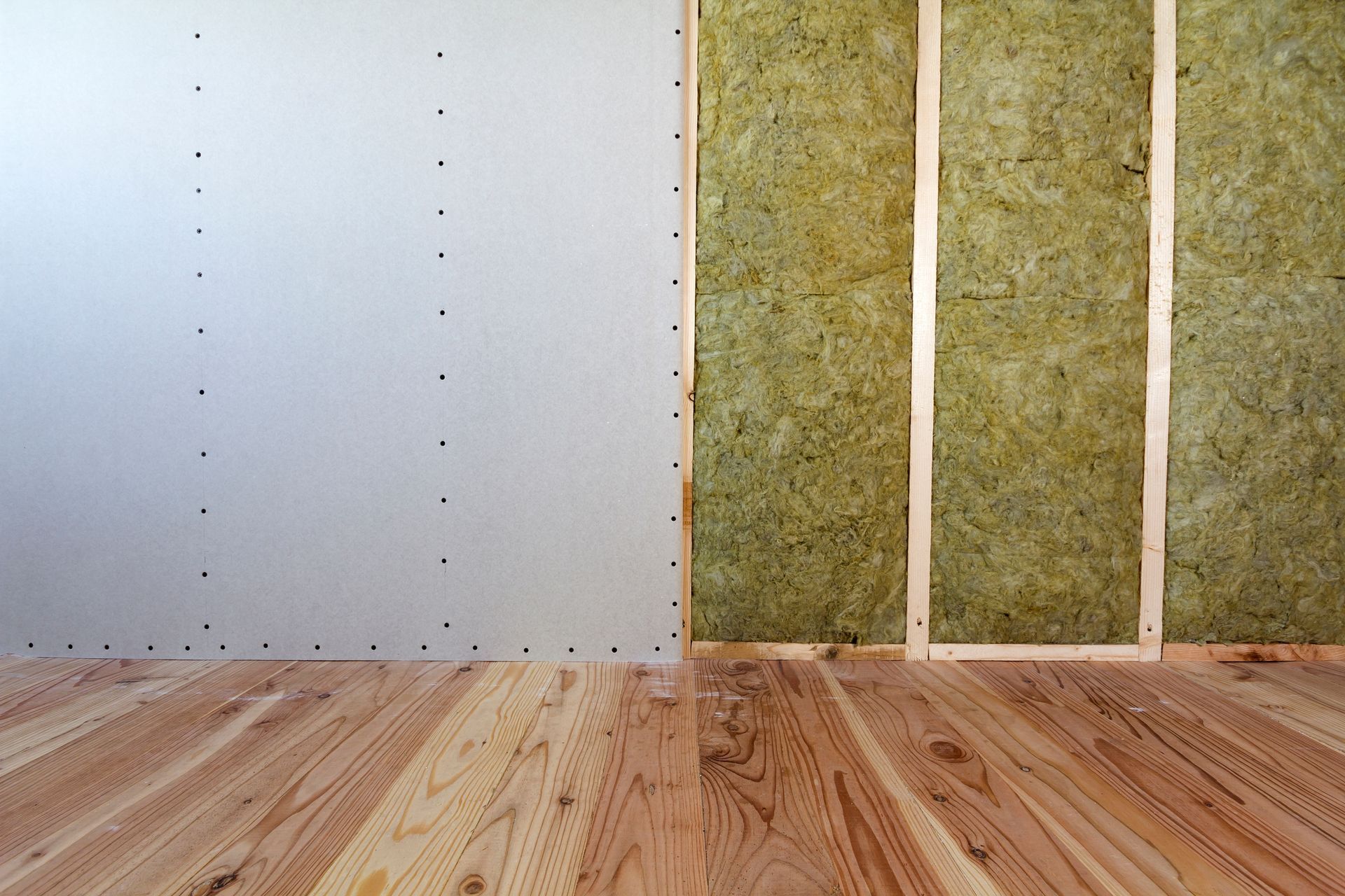 Mur intérieur en construction, montrant l'isolation entre les montants en bois