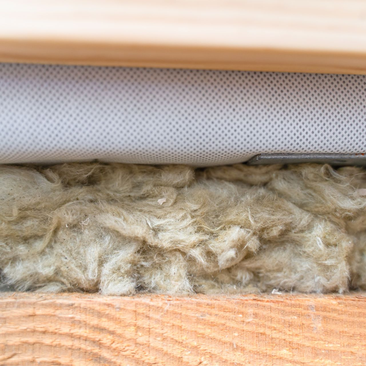 Gros plan sur l'isolation entre les poutres en bois