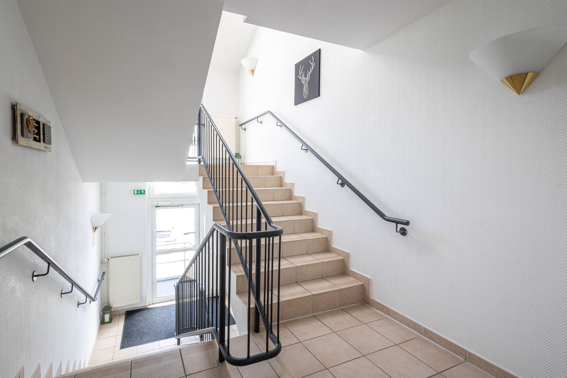 Eine Treppe mit einem Metallgeländer, die in den zweiten Stock eines Gebäudes führt.