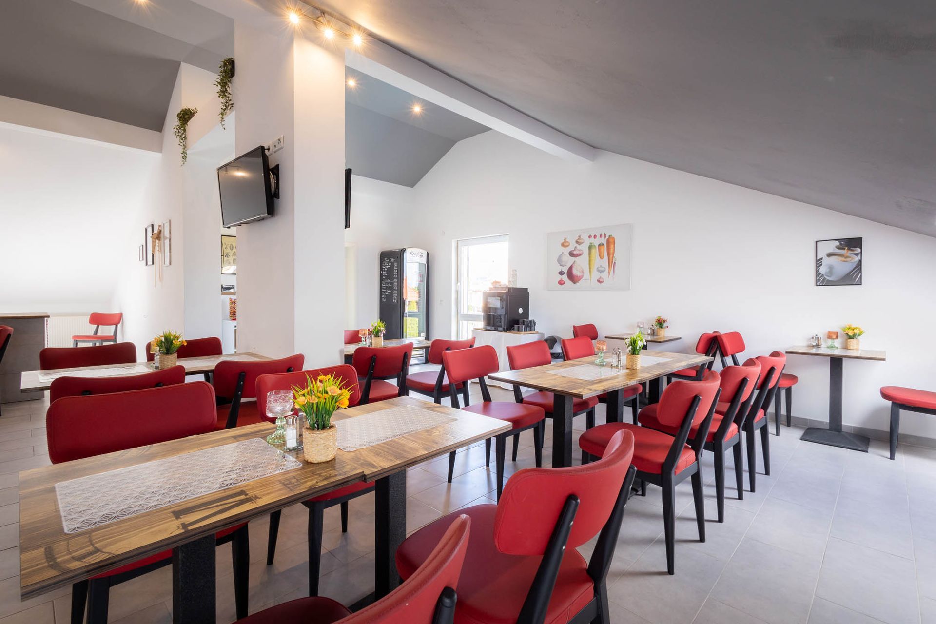 In diesem Raum gibt es viele Tische und Stühle.