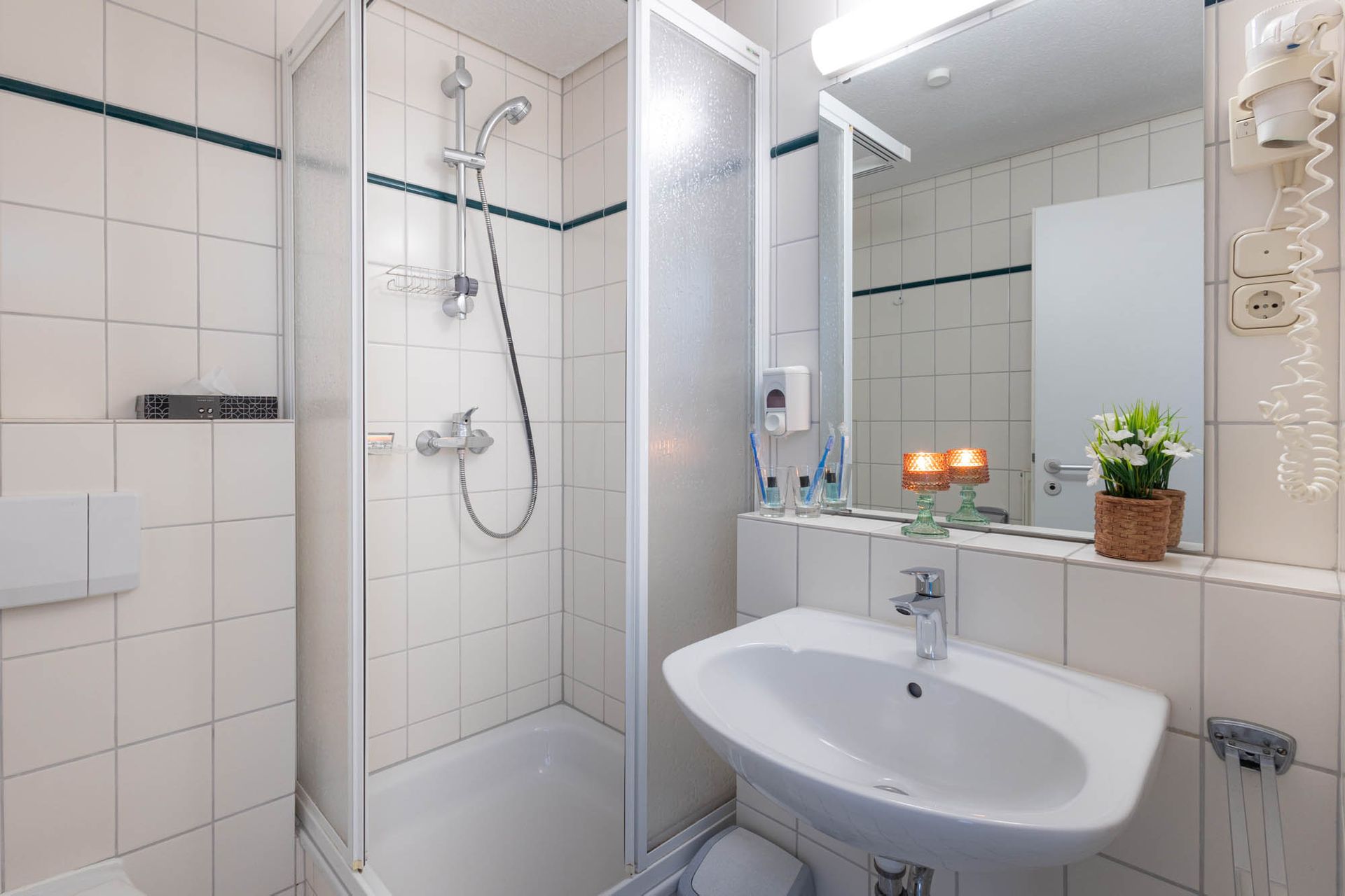 Ein Badezimmer mit Waschbecken, Toilette, Dusche und Spiegel.