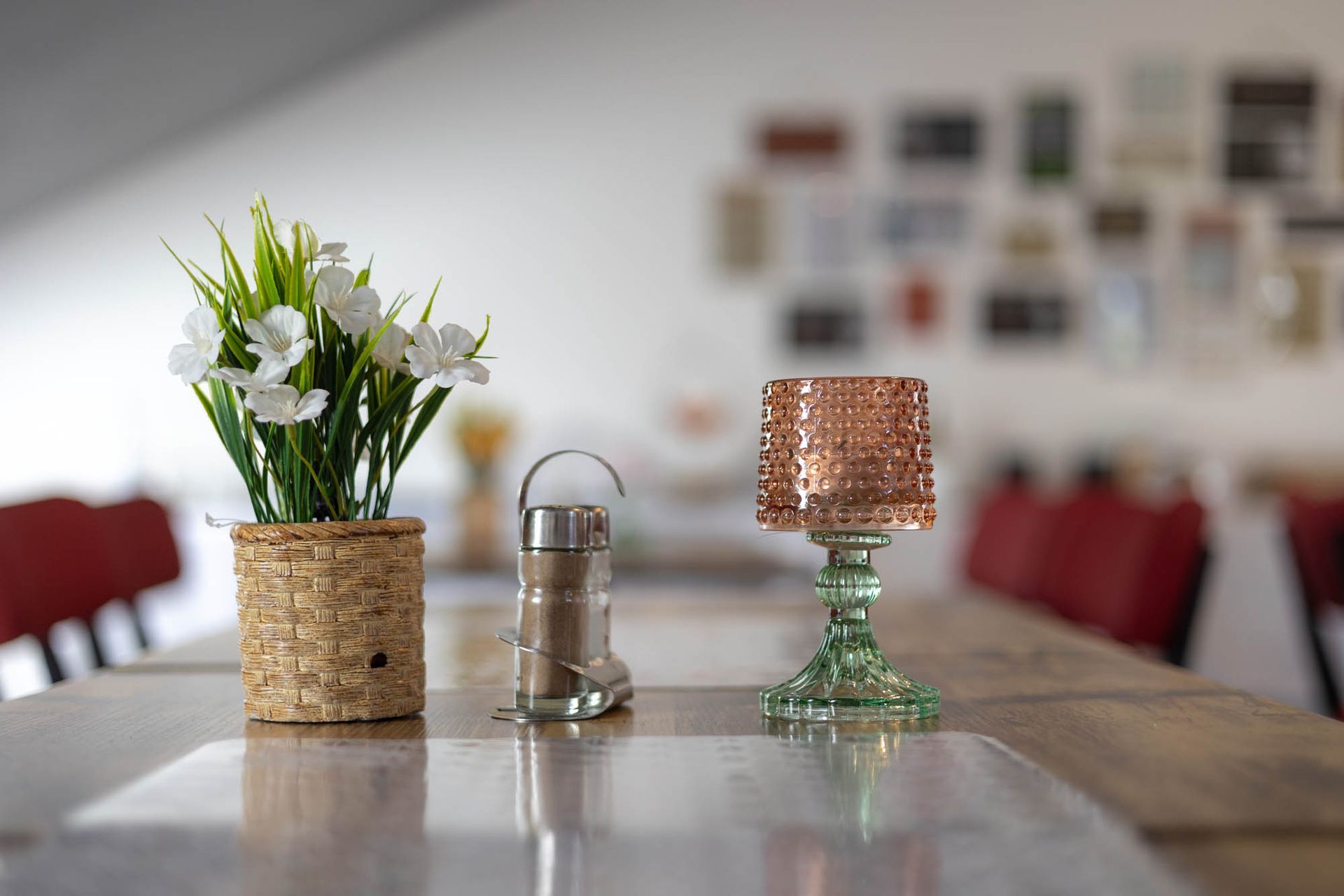 Ein Tisch mit einer Blumenvase und einer Lampe darauf.