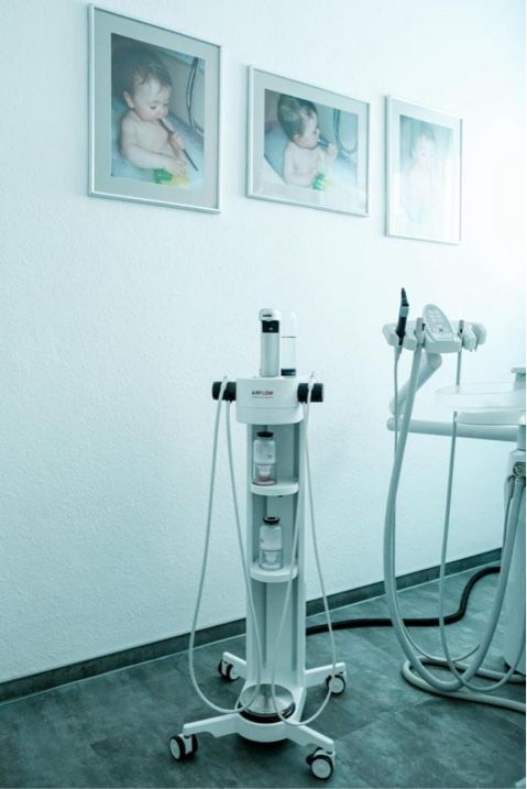 Eine Zahnarztpraxis mit Bildern an der Wand und einer Maschine auf dem Boden