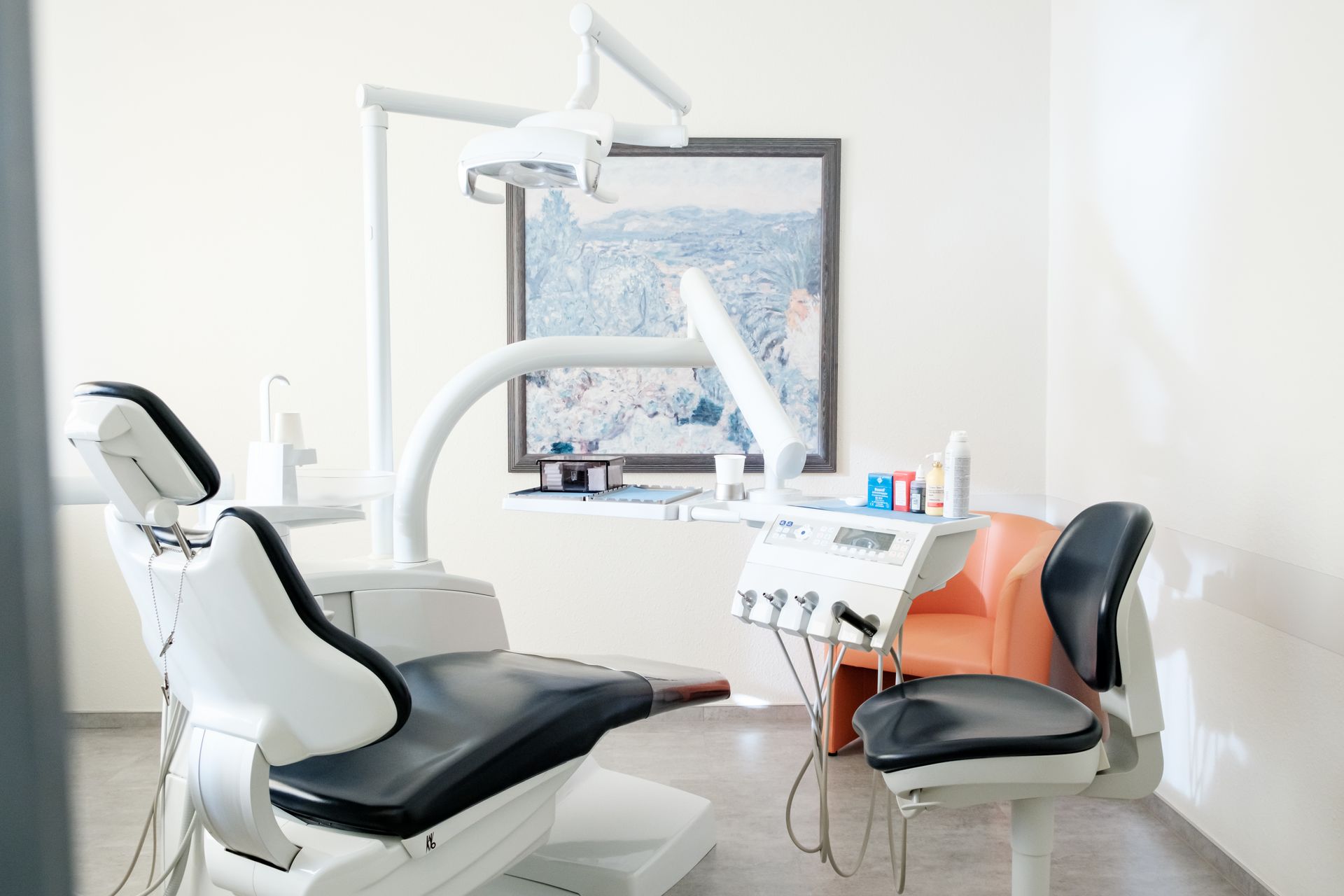 Eine Zahnarztpraxis mit einem Zahnarztstuhl und einem Bild an der Wand.
