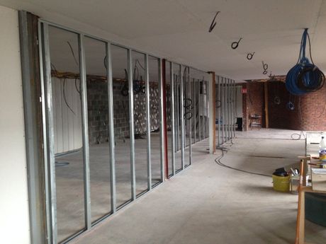 Intérieur rénové avec ossature métallique, câblage apparent et matériaux de construction sur un sol en béton
