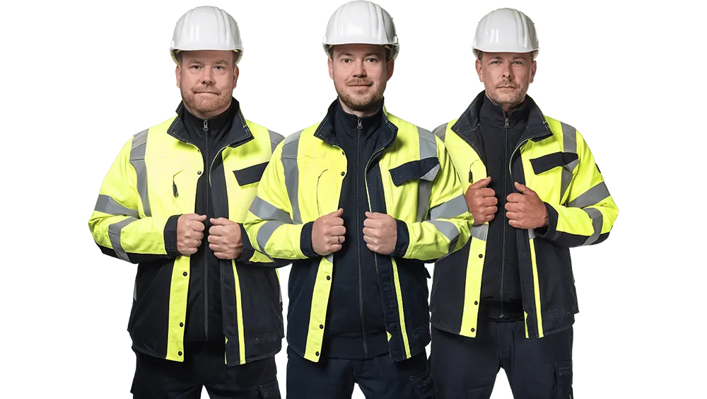 Three construction workers in reflective jackets and hard hats.