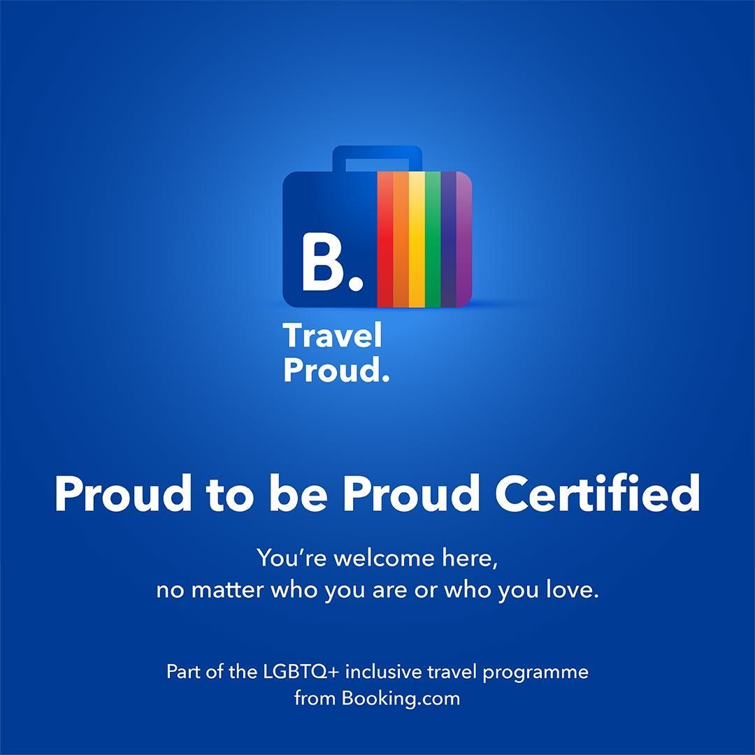 Booking.com Travel Proud logo with rainbow suitcase and message: Proud to be Proud Certified – LGBTQ+ inclusive travel programme