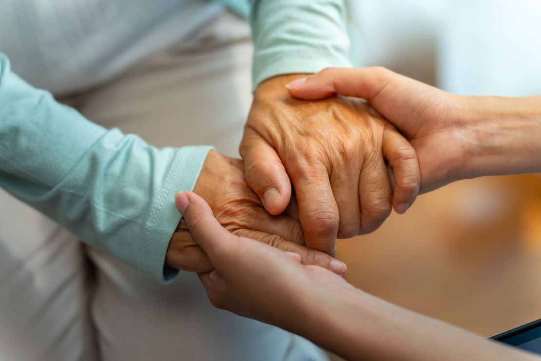 Mains jointes d'une dame et d'une personne âgée