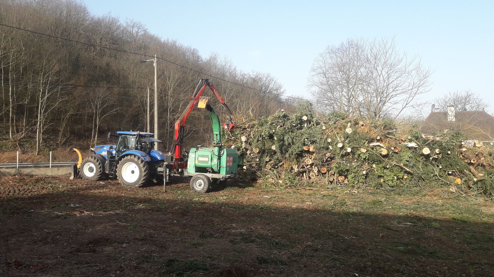 Bois déchiqueté devenu du bois de chauffage et ramassé par un tracteur