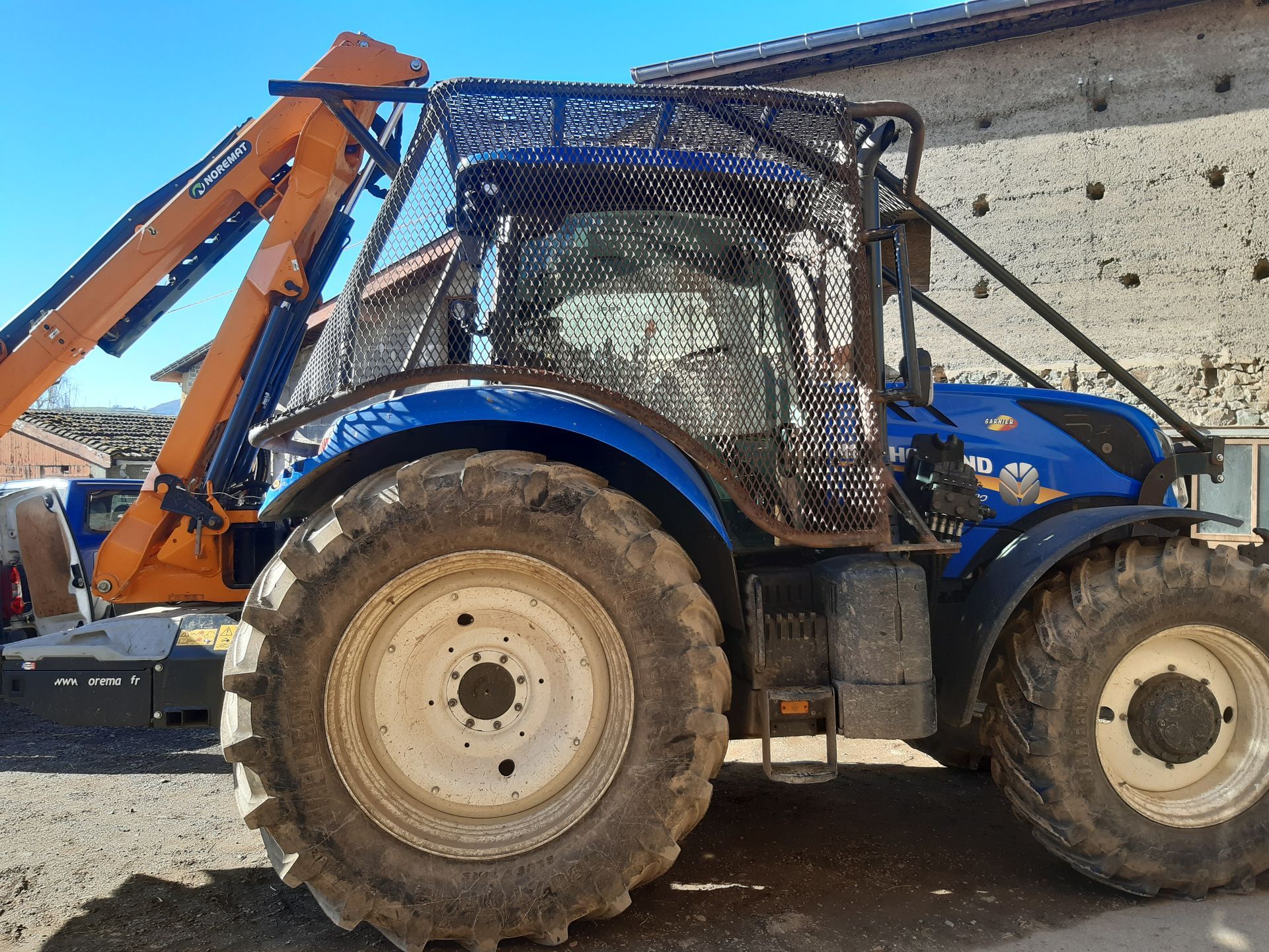Tracteur bleu avec un équipement de débroussaillage