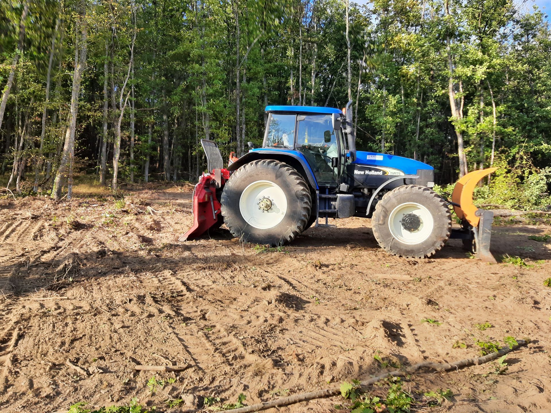 Tracteur bleu sur un terrain pour accomplir des travaux forestiers