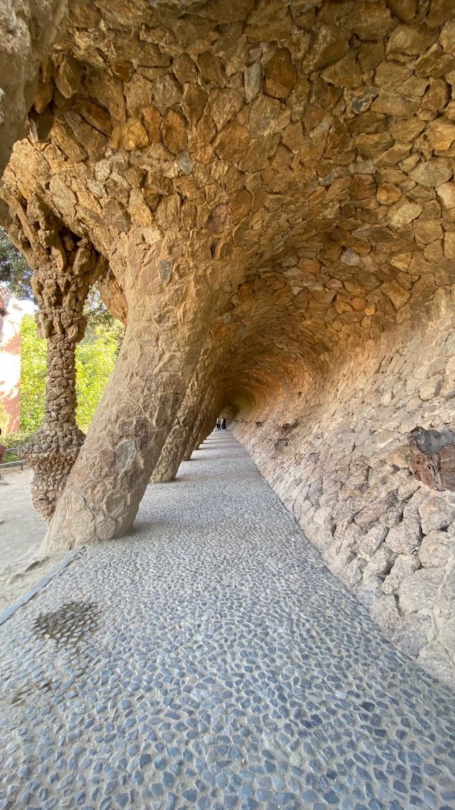Un túnel de piedra en un parque con un camino que lo atraviesa.