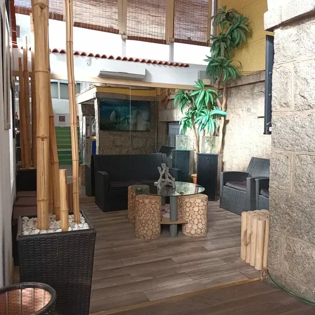 Una sala de estar con un sofá, una mesa y sillas.