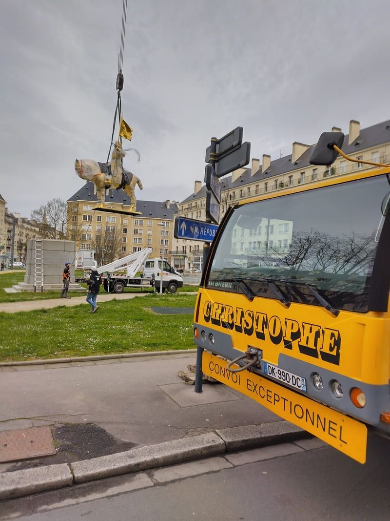 Camion jaune devant la statue de Jean d'Arc