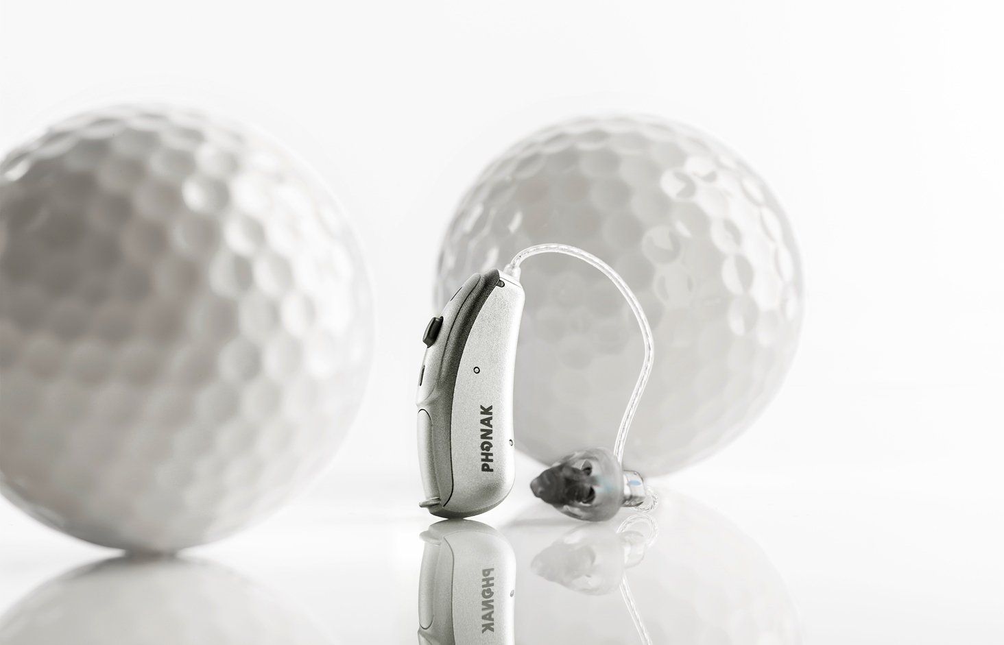 Hörgerät vor Golfbällen