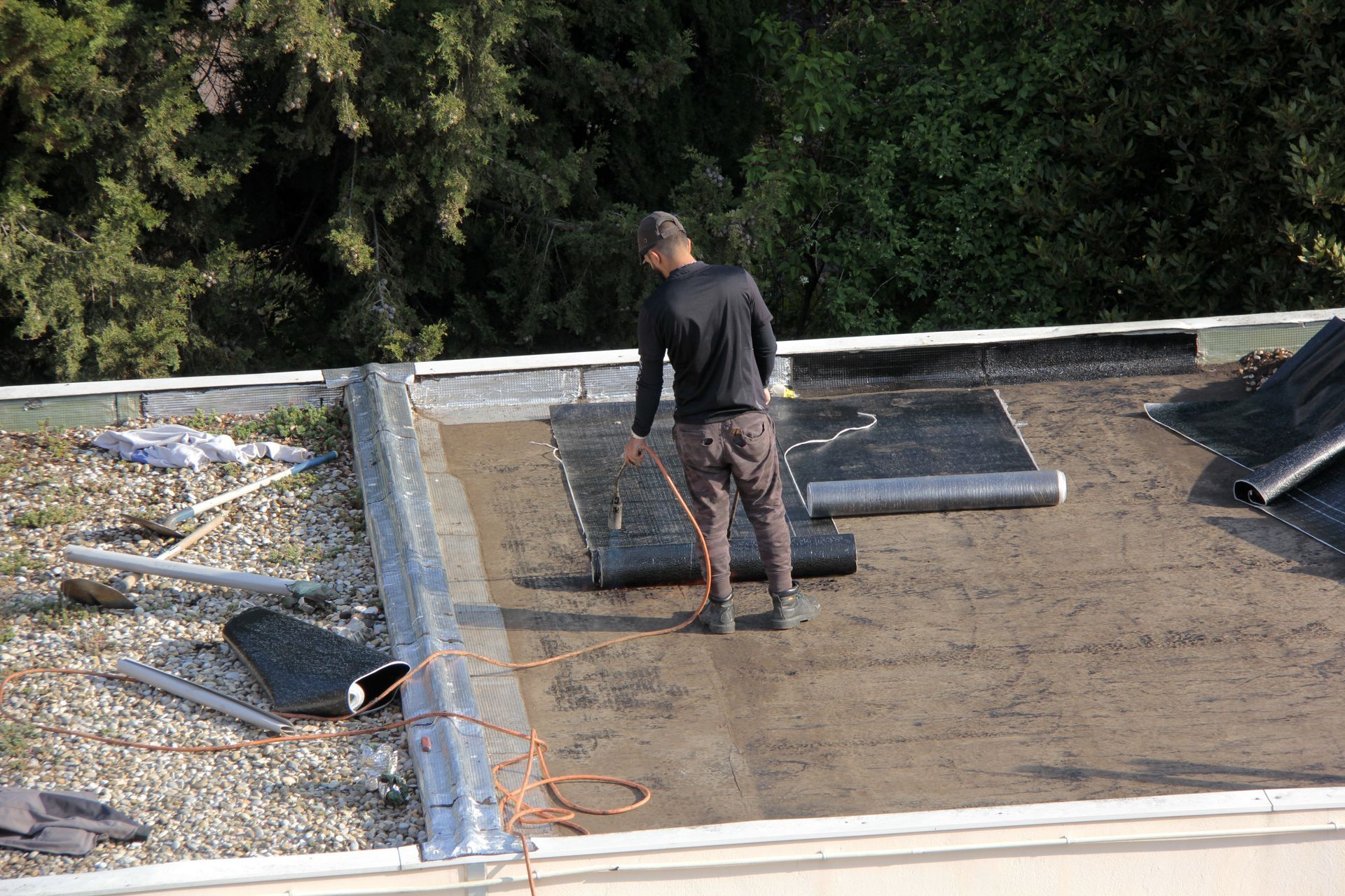 Un artisan qui étanchéifie un toit terrasse