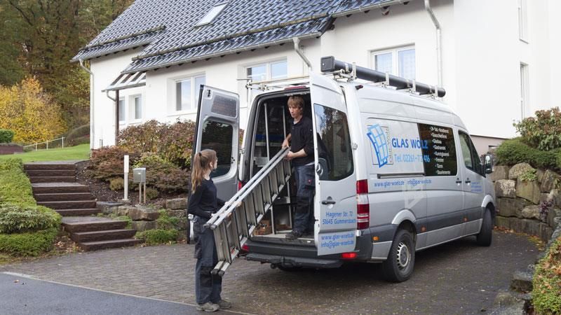 Ein Mann und eine Frau beladen einen Lieferwagen vor einem Haus