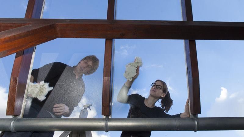 Ein Mann und eine Frau putzen ein Fenster