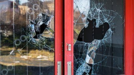 Eine rote Tür mit zerbrochenem Glas darauf.