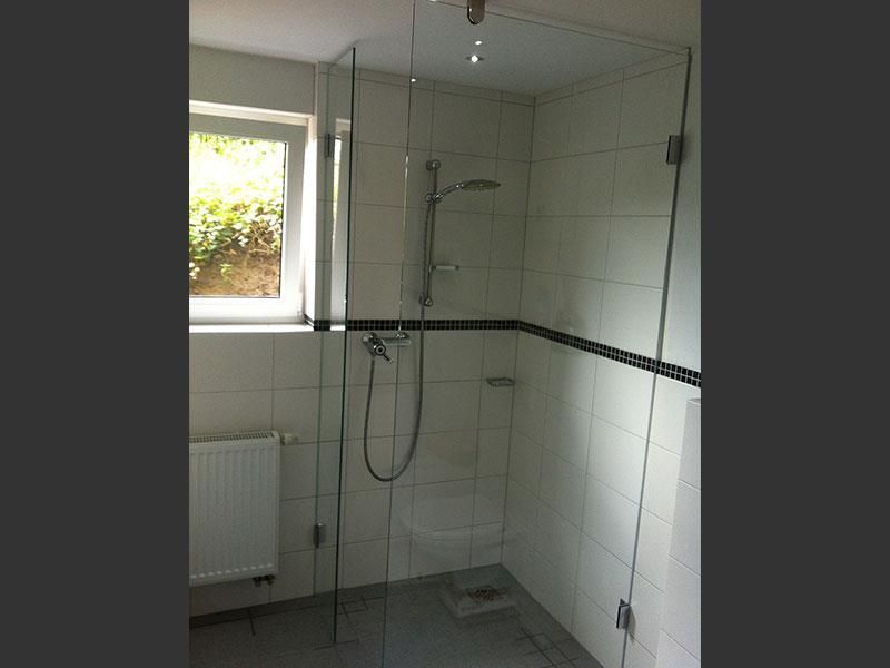 Ein Badezimmer mit ebenerdiger Dusche und Fenster