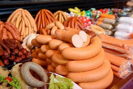 Auslage verschiedener Wurstsorten in unterschiedlichen Farben und Ausführungen auf einem Tisch.