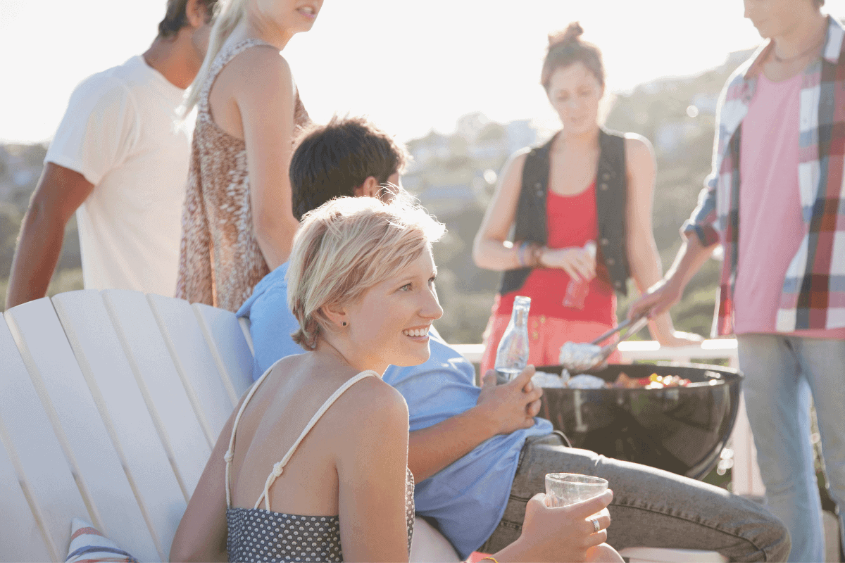 Eine Gruppe Leute grillt am Strand.