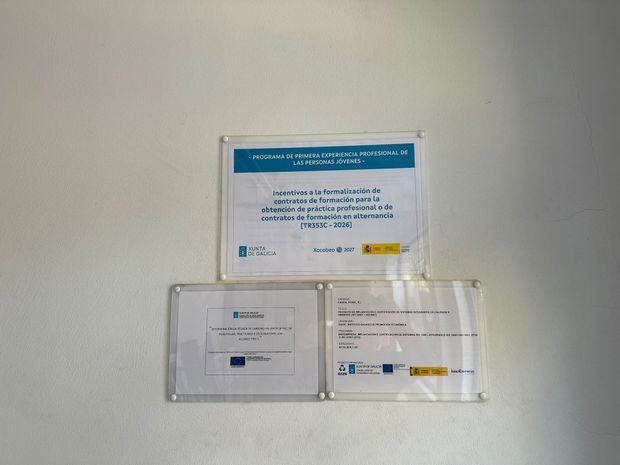 Tres carteles de pared en soportes transparentes, con encabezados azules y texto blanco sobre una pared lisa.