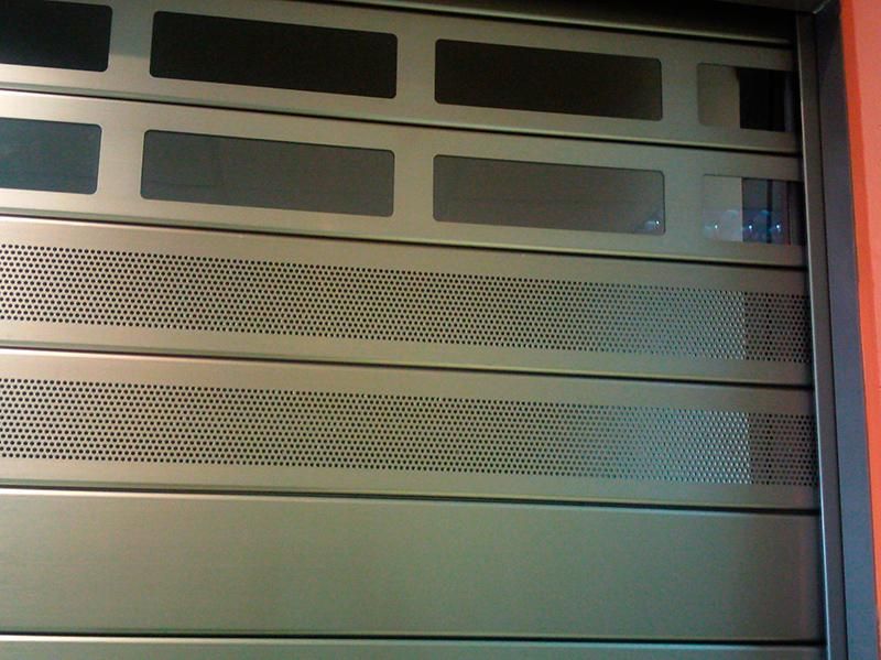 Rack de servidores de malla metálica con paneles oscuros y luz indicadora azul.