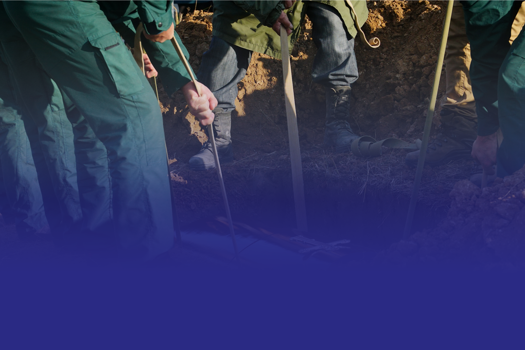 Des personnes posent un cercueil dans la terre