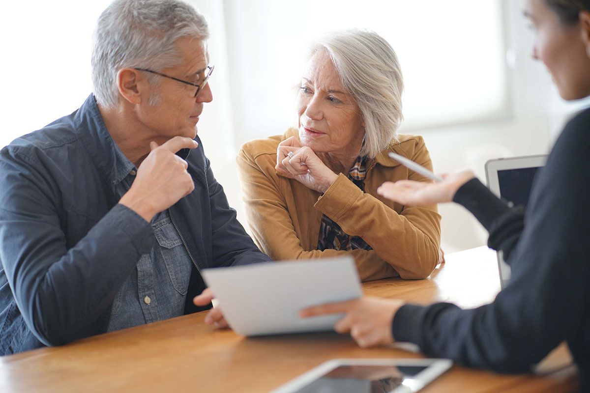 Un couple de retraités qui fait des papiers avec un conseiller