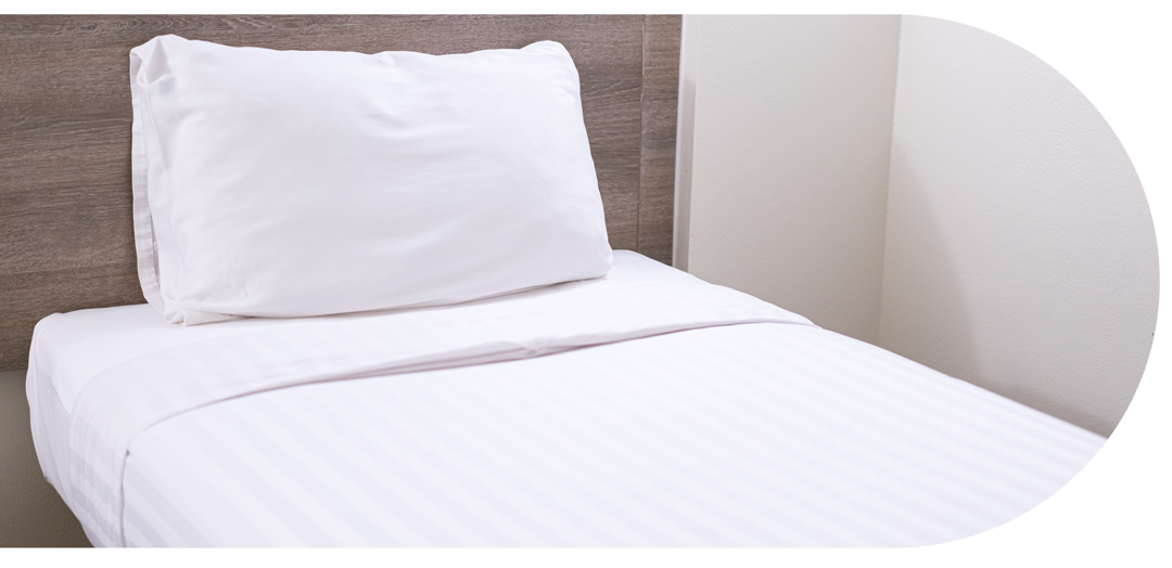 Lit blanc avec plaque en bois au dos