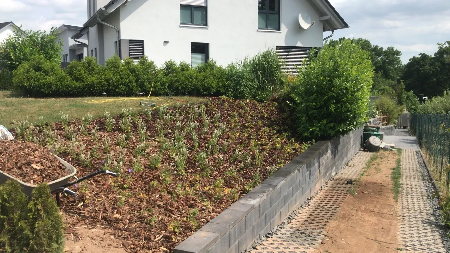 Ein weißes Haus steht auf einem Hügel neben einem Garten.