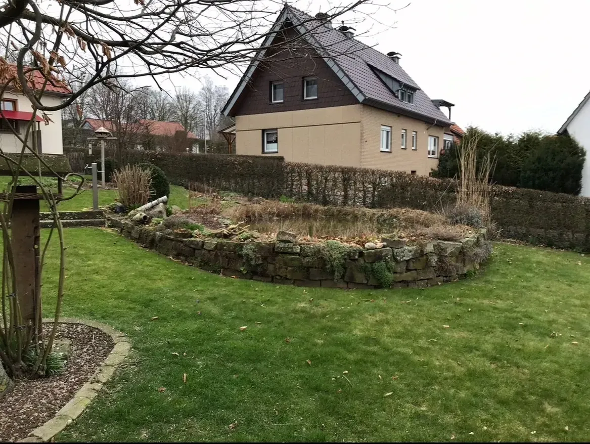 Ein großes Haus mit einem Teich davor