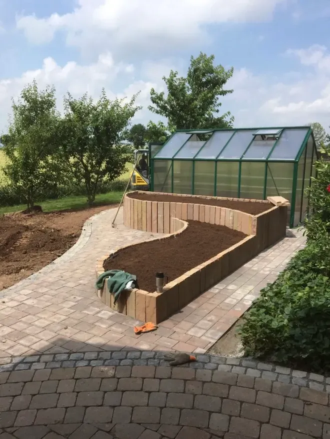 Im Hinterhof eines Hauses wird ein Gewächshaus gebaut